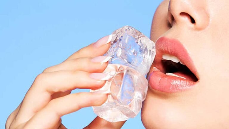 चेहरे पर बर्फ रगड़ती हुई महिला।