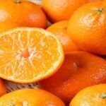 बाजार में मीठे और ताजे संतरे का चयन करते हुए