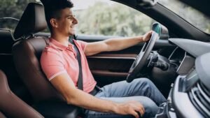 ड्राइविंग के दौरान कार इंजन की देखभाल करते हुए ड्राइवर